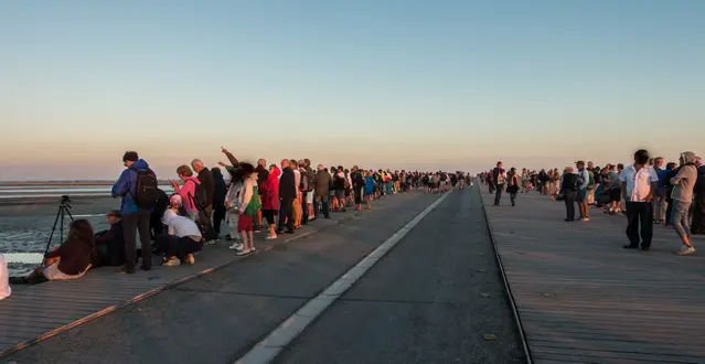 Visitors are waiting for the spring tide on the bridge in front of Mont Saint Michel
