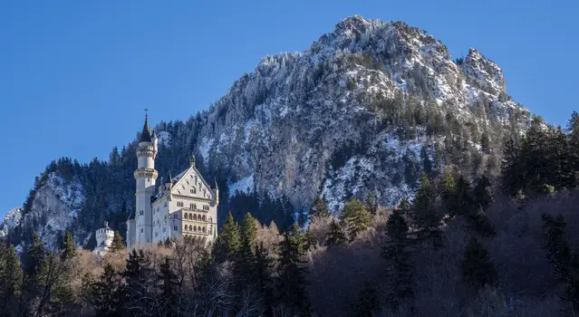 Neuschwanstein Castle with mountain in the back covered with snow in winter