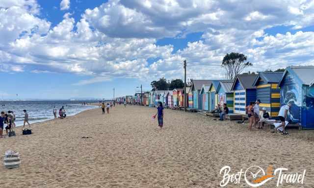 Visitors at Brighton Beach at the huts, at the sea and walking