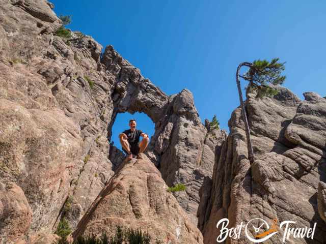 A hiker in front of the circular rock hole