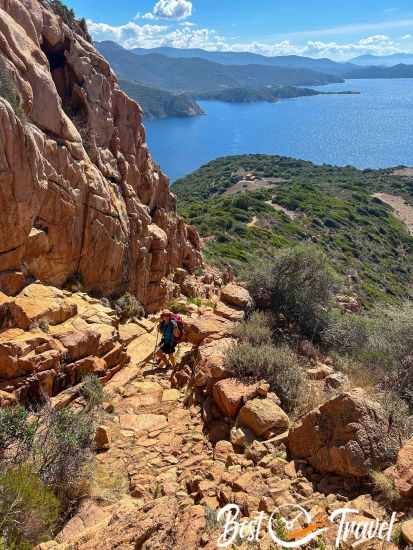 A female hiker on the last part with a spectacular landscape in the back.