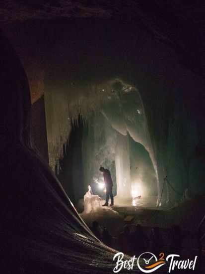 A guide under a rock formation and ice veil with minimal lightning.