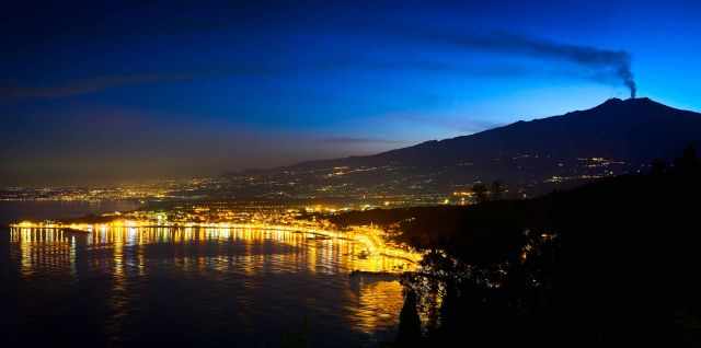 Etna with smoke plume out of the crater at sunset from the distance