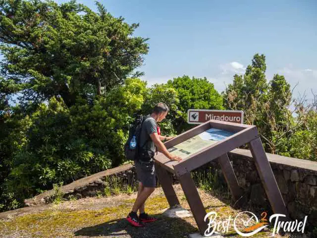 A hiker at an information board at a viewpoint.