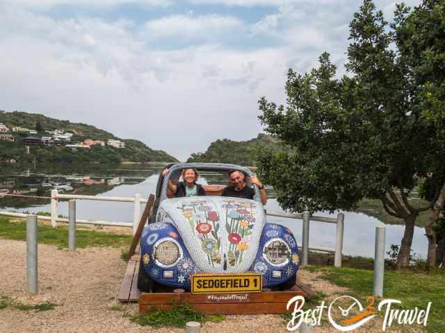 A beetle mosaic and two persons sitting in it.