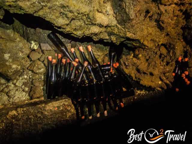 Wine bottles in a hole at the beginning of the cave.