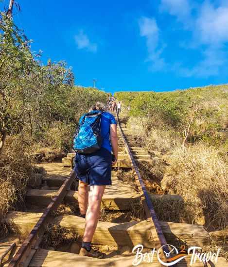 A woman hiker ascending between the railroad ties.