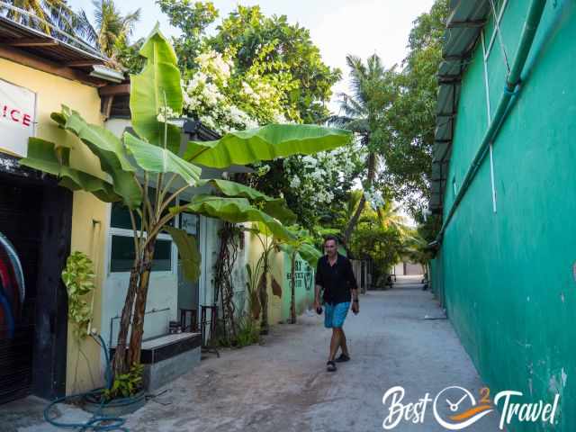 A man walking on a gravel road in the village.