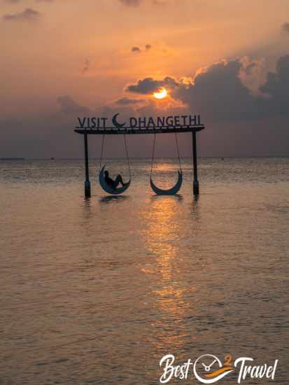 A visitor on the moon swing at sunset.