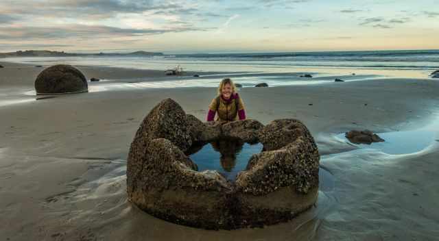 Moeraki in spring - woman behind a broken Moeraki