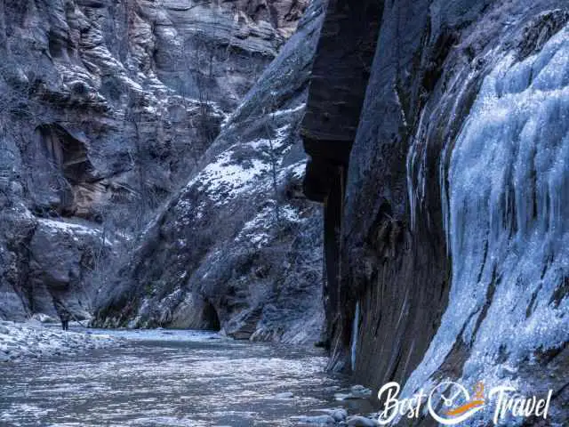 One hiker in the Narrows with icicles on either side.