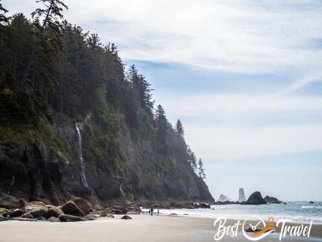 Visitors at Rialto Beach close the waterfall.