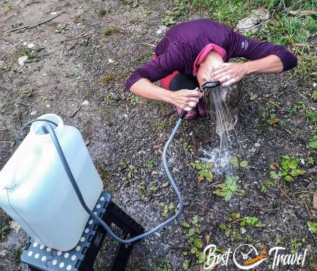 A woman washing the hairs with an immersion pump shower