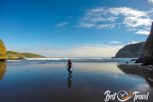 A woman walking on the hidden dry beach at low tide.