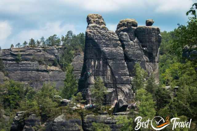 Three rocks next to each other and a climber secured with a rope