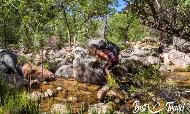 Me scrambling over rocks and underneath a tree.