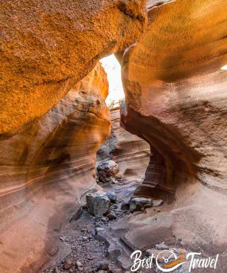 The orange walls and huge boulders on the canyon floor